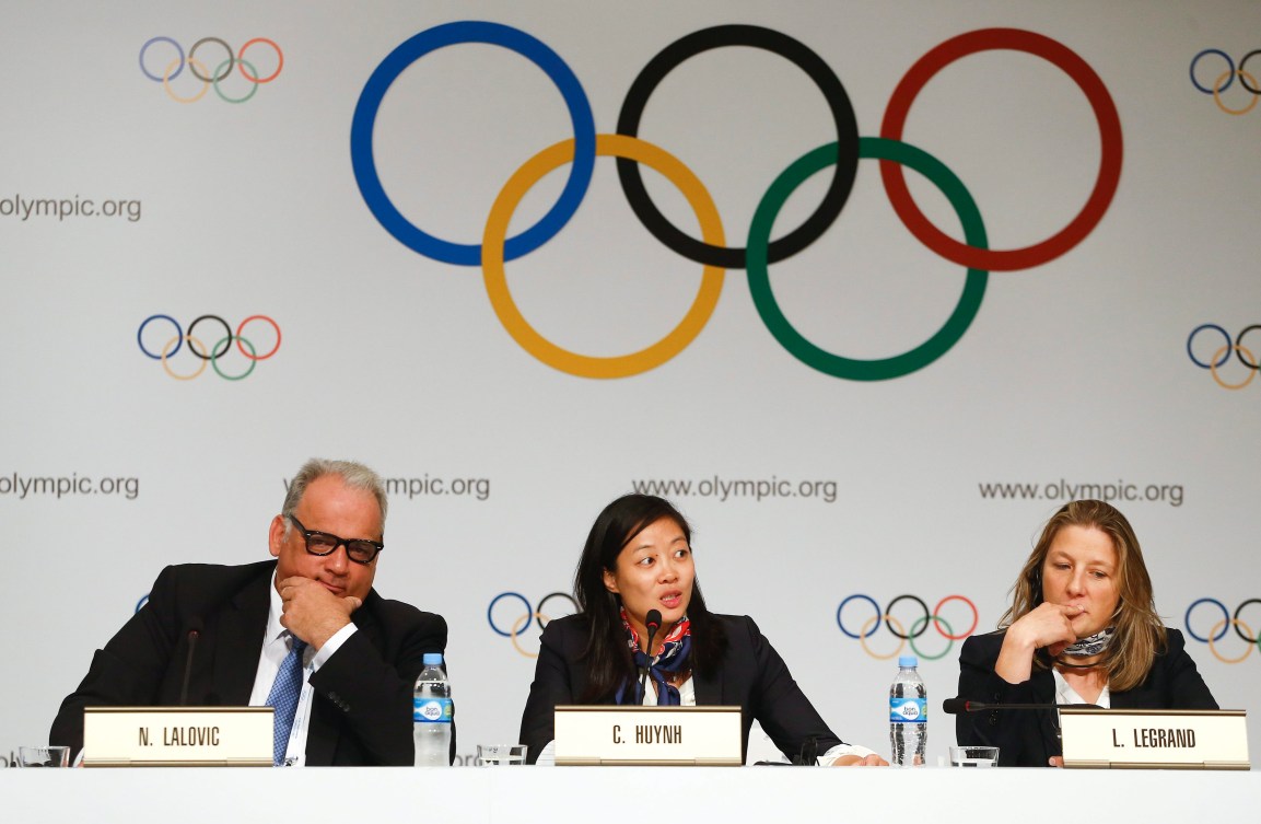 Carol Huynh (centre) accompagnée de Nenad Lalovic, président de la FILA (gauche) et de Lise Legrand, vice-président de la FFL (droite), témoignant pour la réintégration de la lutte au programme olympique devant le Comité olympique international durant la conférence de Buenos Aires, 2013.(AP Photo/Victor R. Caivano)