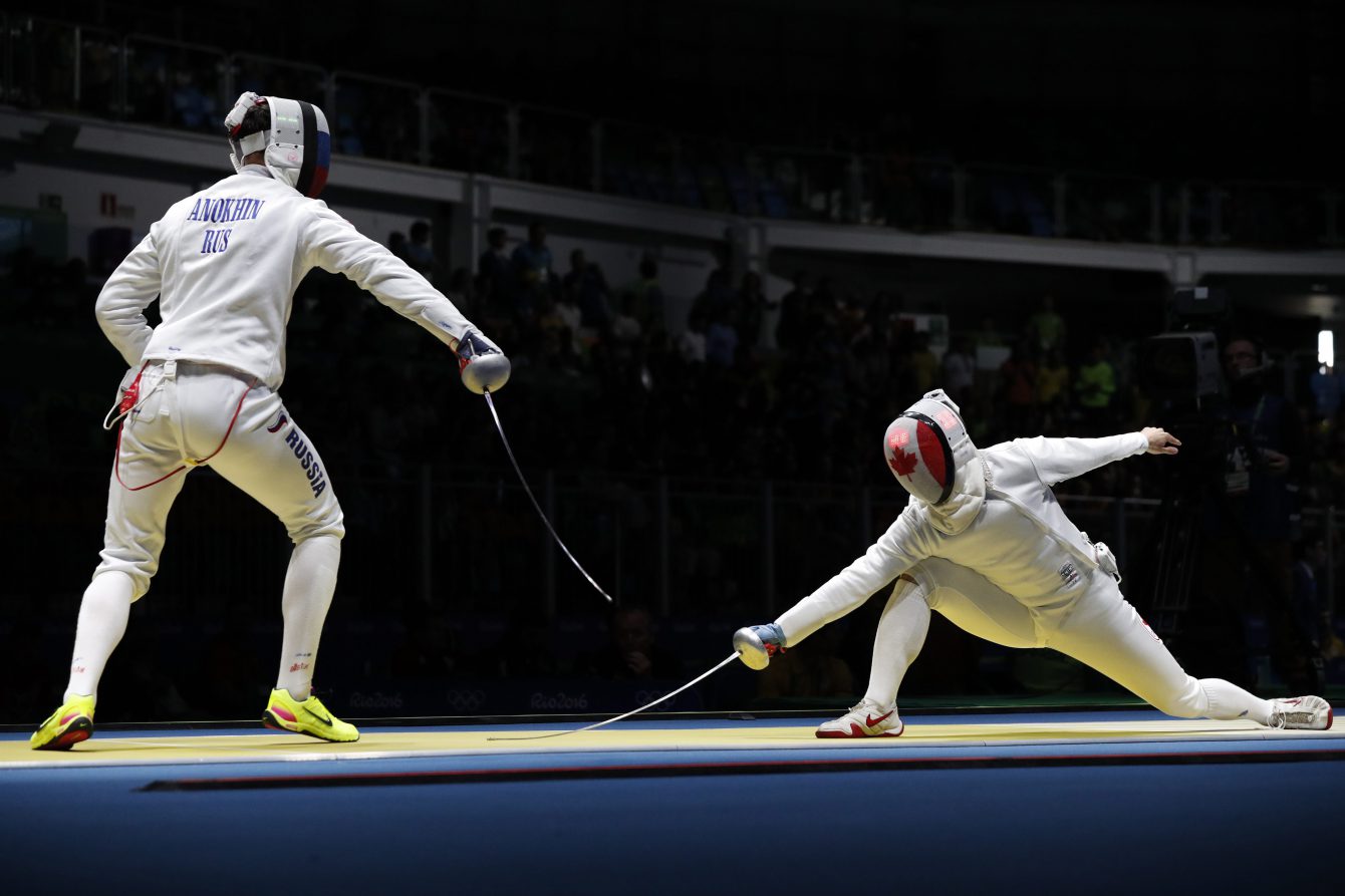Vadim Anokhin from Russia, left, and Maxime Brinck-Croteau from Canada, competes in the men's epee individual fencing event at the 2016 Summer Olympics in Rio de Janeiro, Brazil, Tuesday, Aug. 9, 2016. (AP Photo/Vincent Thian)