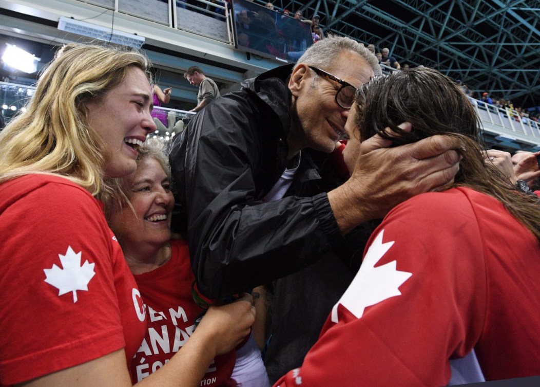 Penny Oleksiak, à droite, célèbre sa victoire avec ses parents et sa sœur, le 12 août 2016. THE CANADIAN PRESS/Sean Kilpatrick