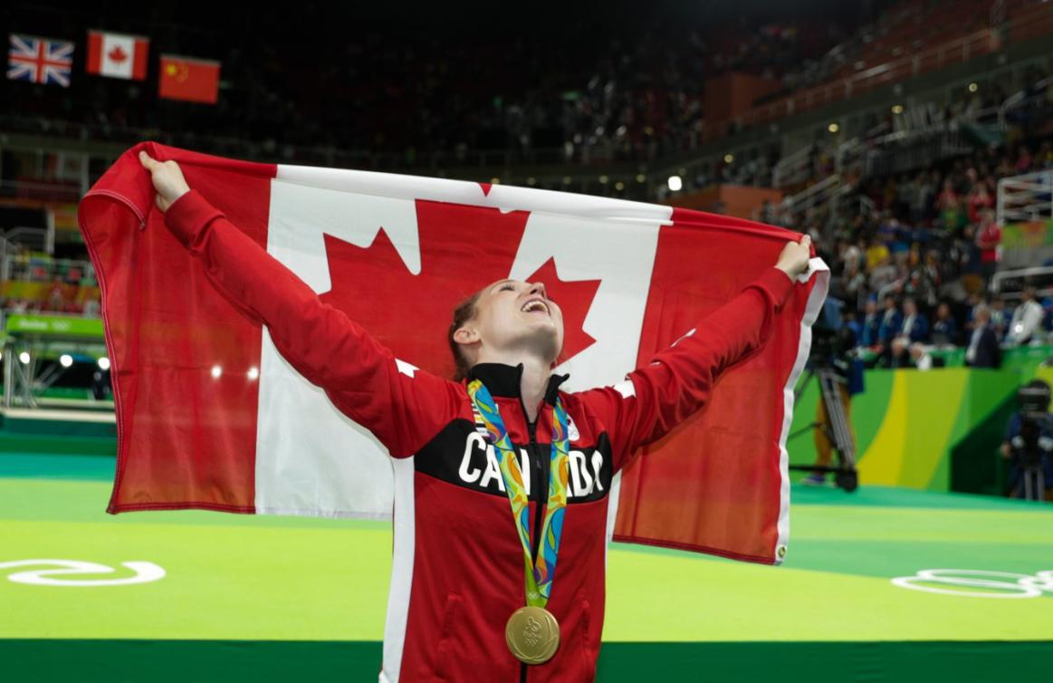 Rosie Maclennan avec le drapeau canadien et sa médaille d'or de l'épreuve de trampoline aux Jeux de Rio. 12 août 2016. Photo Jason Ransom