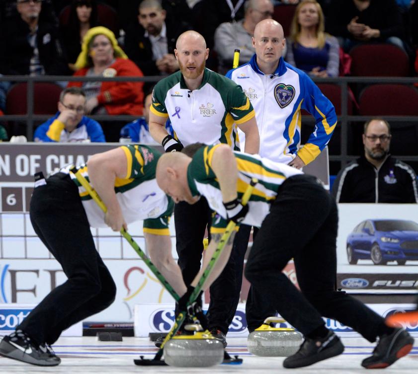 Les rivaux et compatriotes Brad Jacobs (gauche) et Kevin Koe regardent le placement de pierre de l'équipe Jacobs au Brier 2016 à Ottawa, le 12 mars 2016. THE CANADIAN PRESS/Justin Tang