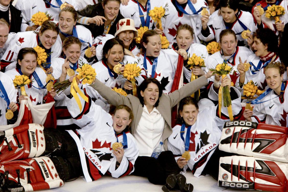 L'entraîneuse de l'équipe féminine canadienne de hockey Danièle Sauvageau (au centre) et son équipe arborant leur médaille d'or posent pour la photo de groupe après avoir battu les États-Unis avec un pointage de 3 -2, le jeudi 21 février 2002, aux Jeux olympiques d'hiver de Salt Lake City. (PHOTO PC/AOC/Mike Ridewood)