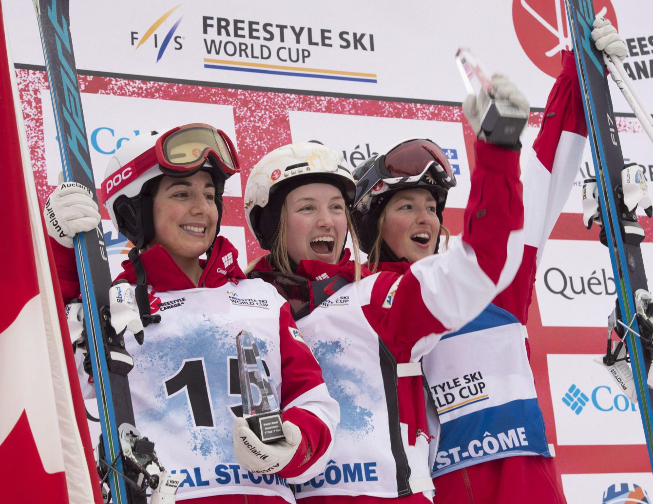 La skieuse acrobatique d'Équipe Canada Justine Dufour-Lapointe (centre) célèbre sa victoire à la Coupe du monde de Val St-Côme aux côtés de sa coéquipière Andi Naude (gauche) et sa soeur Chloé. (Photo : THE CANADIAN PRESS/Jacques Boissinot)