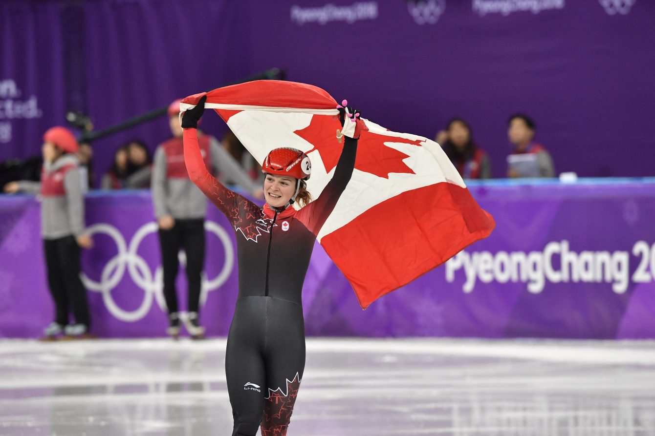 Kim Boutin d'Équipe Canada célèbre avec le drapeau canadien après avoir remoorté la médaille d'argent au 1000 m féminin en courte piste aux Jeux olympiques de PyeongChan, le 22 février 2018.