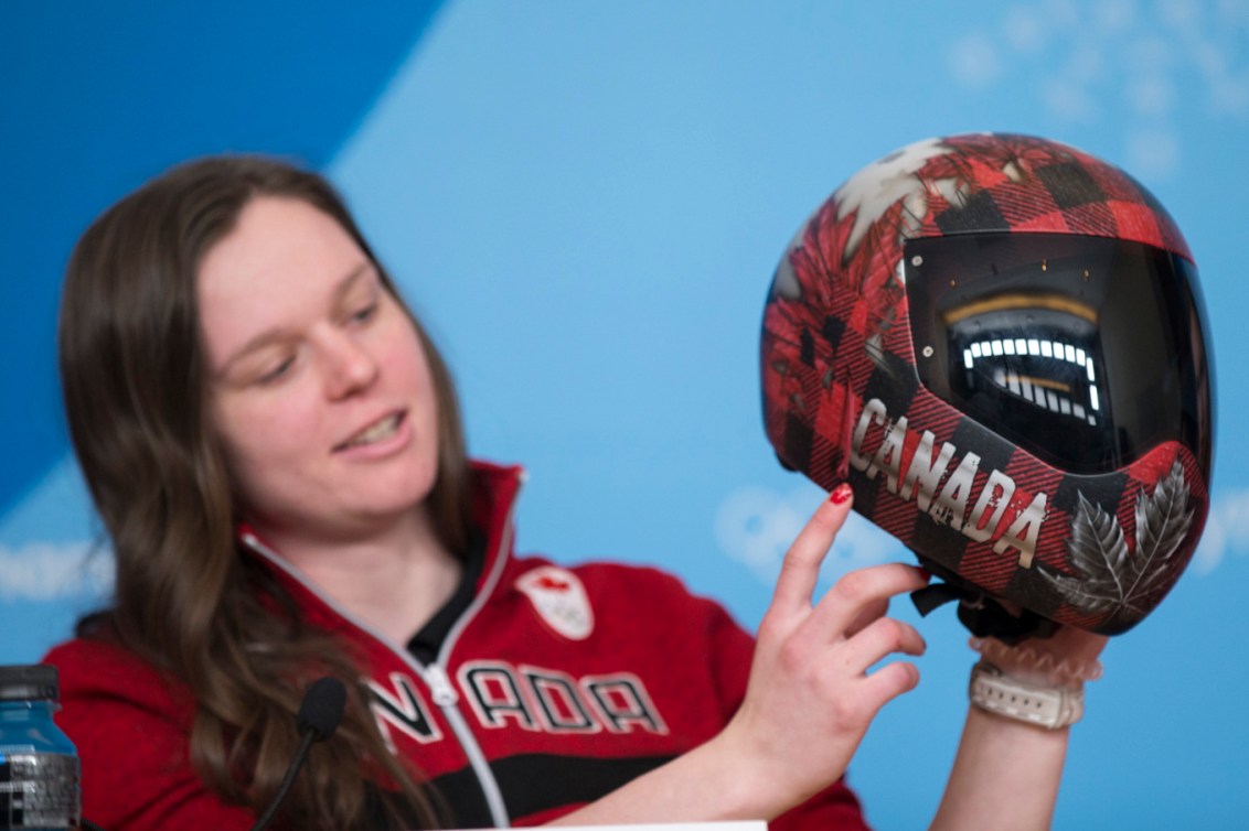 Elisabeth Vathje, athlète de skeleton au sein d’Équipe Canada, montre son casque aux médias à l’approche des Jeux olympiques d’hiver de PyeongChang 2018. Photo : COC/David Jackson