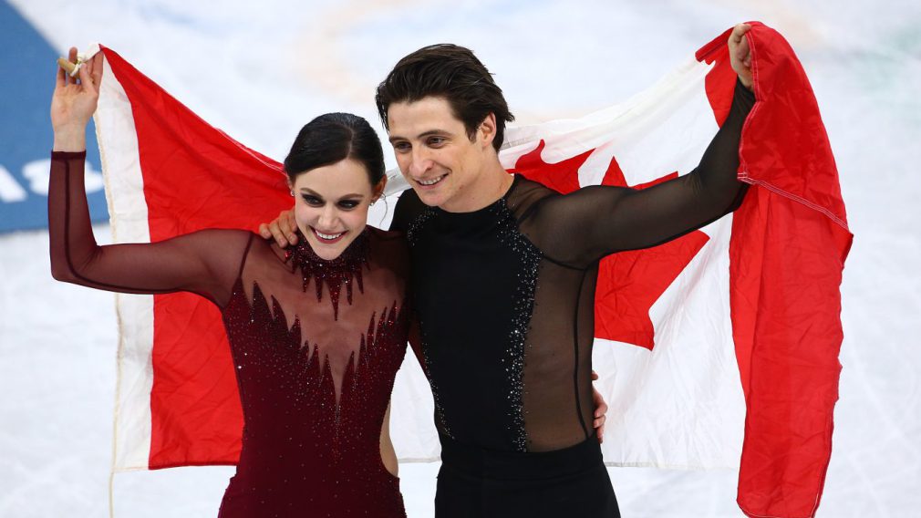 Scott Moir et Tessa Virtue font un tour de glace avec le drapeau canadien
