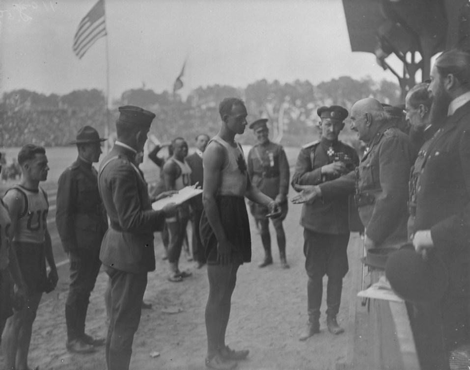 Le roi du Monténégro tend la main vers Army Howard en bordure de la piste d'athlétisme.