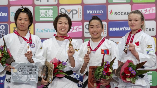 Les quatre médaillées posent sur le podium avec leurs médailles