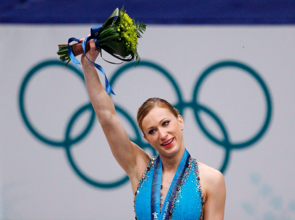 Joannie Rochette lève son bouquet de fleurs en l'air