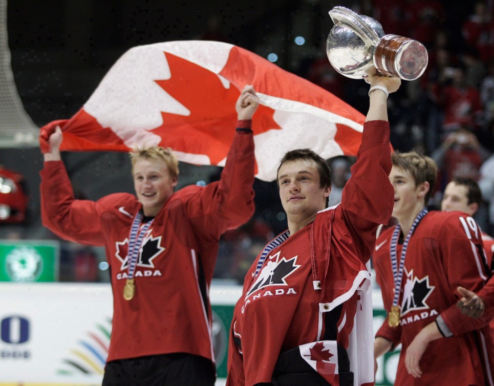 En avant-plan, Legein soulève la Coupe, en arrière-plan, Stamkos porte le drapeau.