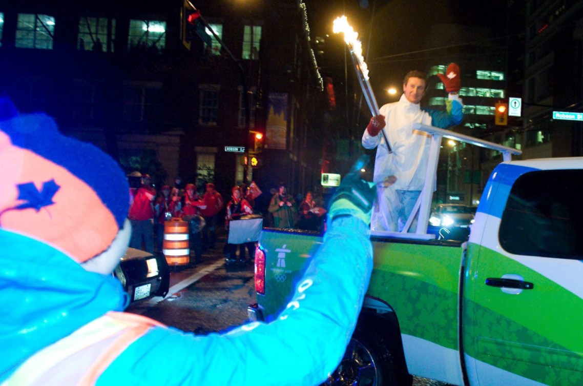Wayne Gretzky tient la flamme olympique à bord d'une voiture.
