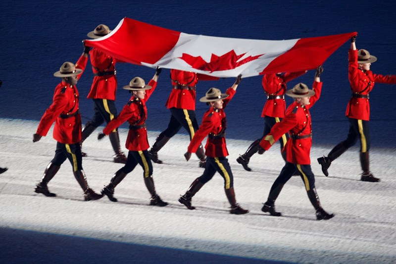 Huit soldats de la GRC portent le drapeau canadien.