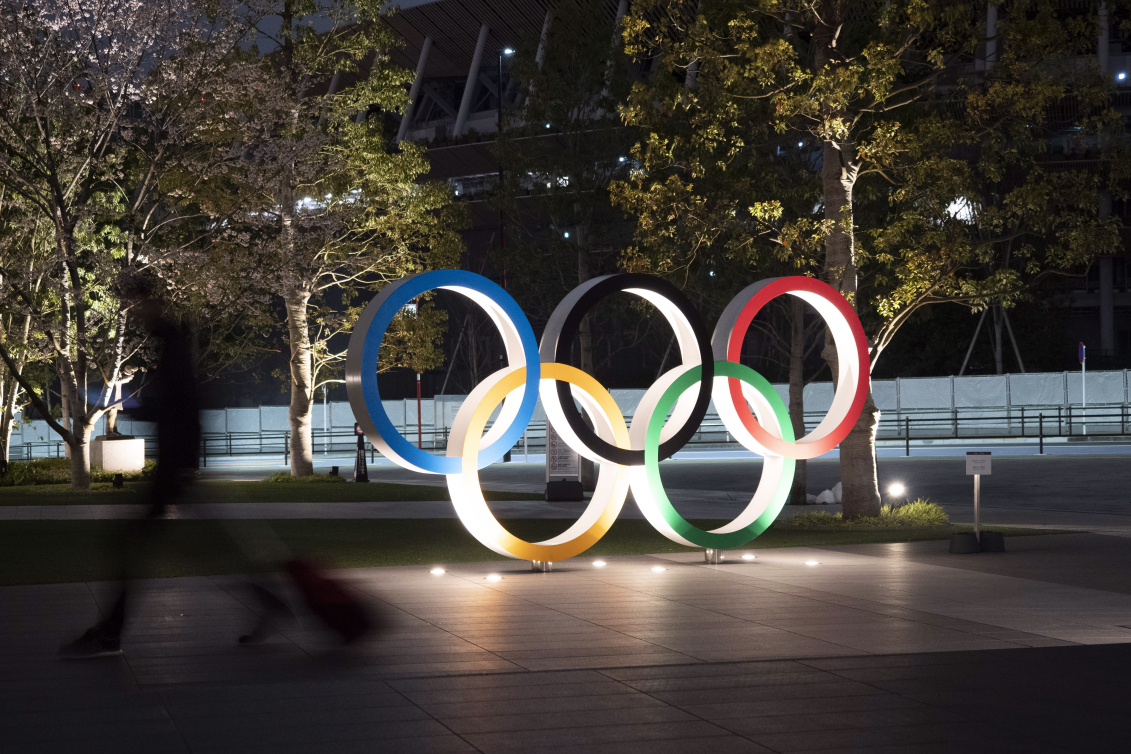 Les anneaux olympiques illuminés dans la nuit.